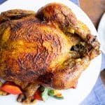 roasted chicken with curry seasoning on white plate, grilled vegetables
