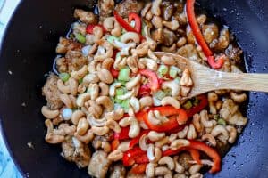 Cashew Chicken Recipe - Cooking and Mixing All Ingredients in a Pan with a Wooden Spoon