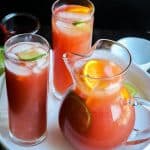 Sangrai mocktail in a pitcher and two other glasss.