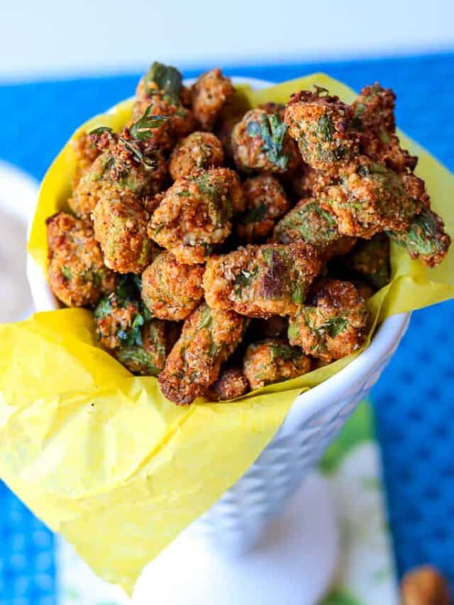 Air fryer okra bites in a white cone cup with yellow lining. Crispy Air Fryer Fried Okra recipe that’s easy to make and fried to a golden crispy texture. A healthier alternative to the traditional deep-fried version. One of the best okra recipes you would want to make. #airfryerfriedokra #airfryerokra #airfriedokra #freshokra #airfryerfrozenokra #friedokrarecipe