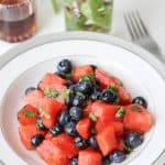 This sweet Watermelon Blueberry Salad combination is exactly what you need as a healthy snack on a light day. Cubed fresh watermelon tossed with blueberries, and maple syrup and fresh lemon juice. Then, topped with chopped mint leaves to create a light and refreshing side dish that will please your guests. #watermelonblueberry #salad