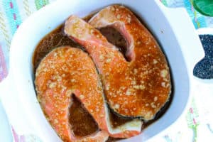 marinaded salmon steaks in white bowl