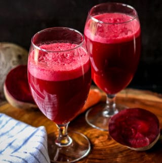 Beets Carrots Apple Juice Recipe in glasses on wooden cutting board -Healthy