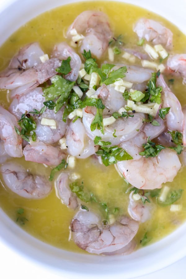 shrimp in garlic butter mixture in a white bowl