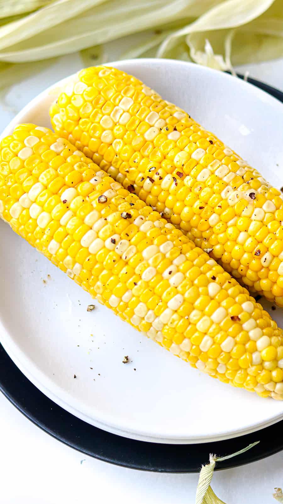 Sweet corn topped with butter and ground pepper