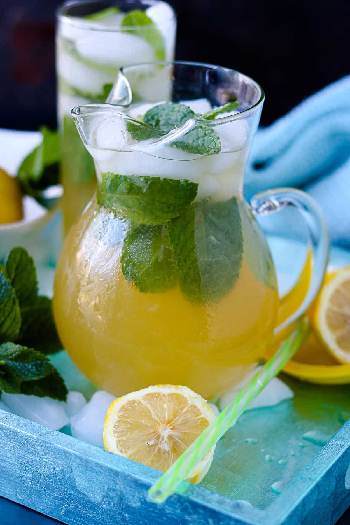 Haitian Jus Citron In glass pitcher with mint and lemon halves