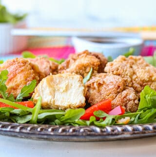 Japanese Fried chicken on a bed of mixed greens and red bell peppers