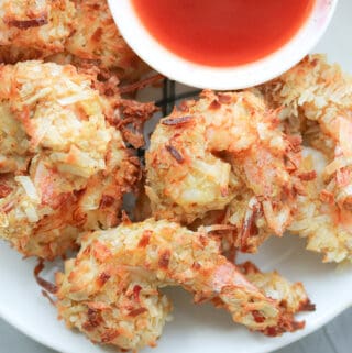 Shrimp coated with coconut flakes air fried on white plate