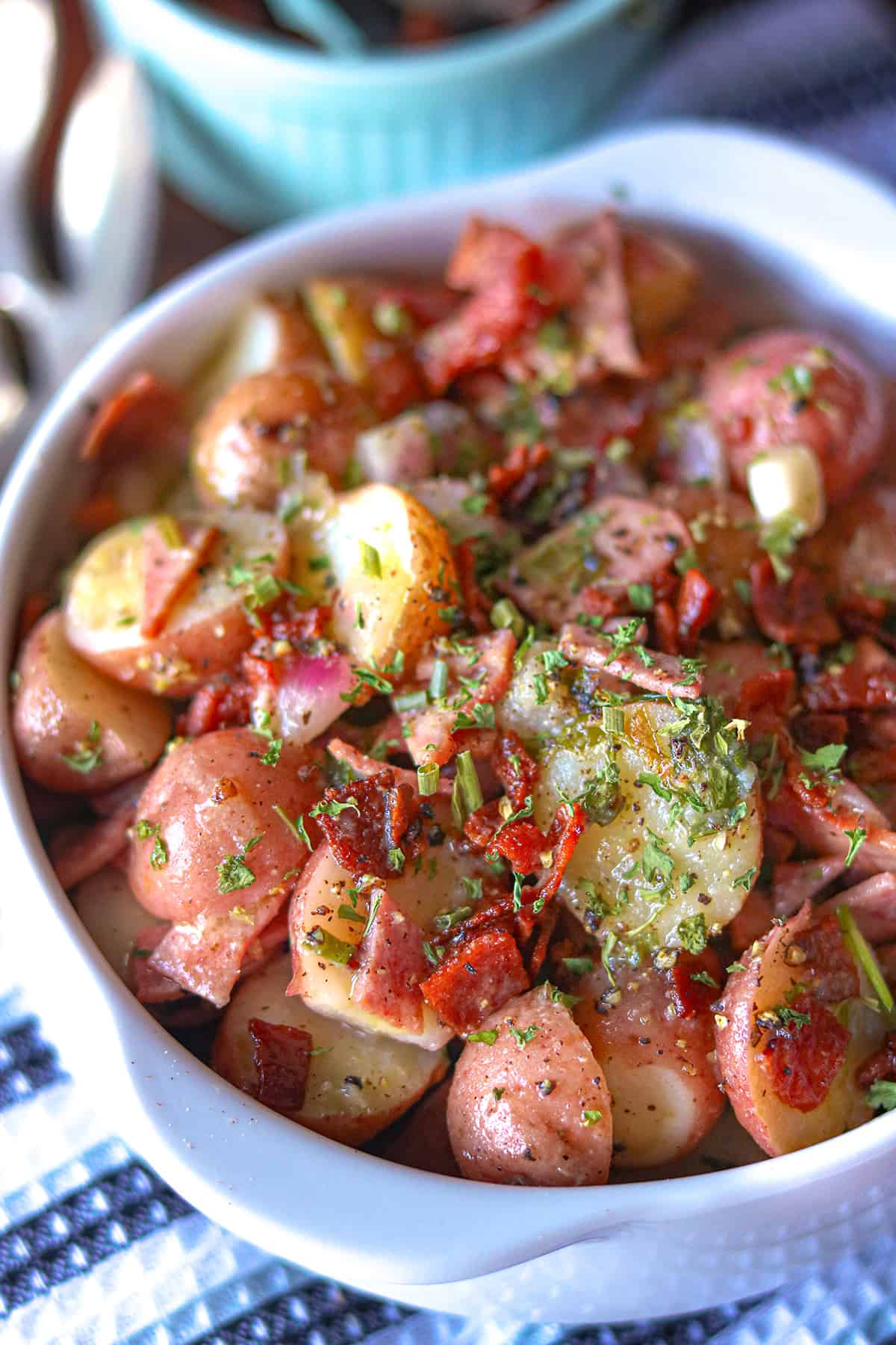 German potato salad topped with herbs and bacon