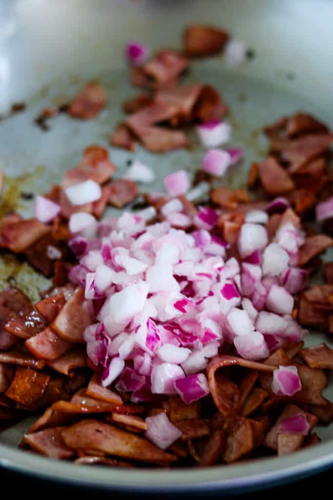 turkey bacon and red onions cooking in skillet