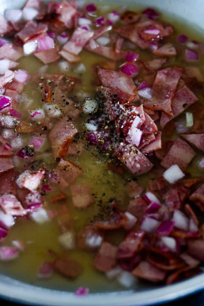 bacon, onions, and vinegar cooking in skillet