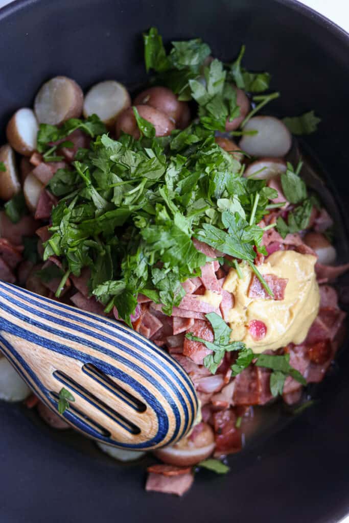 potatoes topped with mustard, bacon mixture and fresh herbs