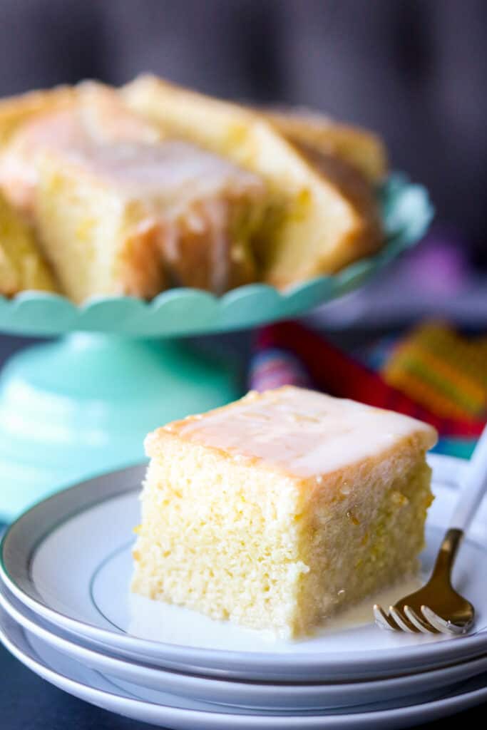 orange cake square on white plate with fork