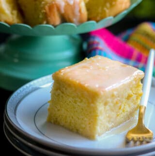 Zesty Orange cake square on white plate with fork