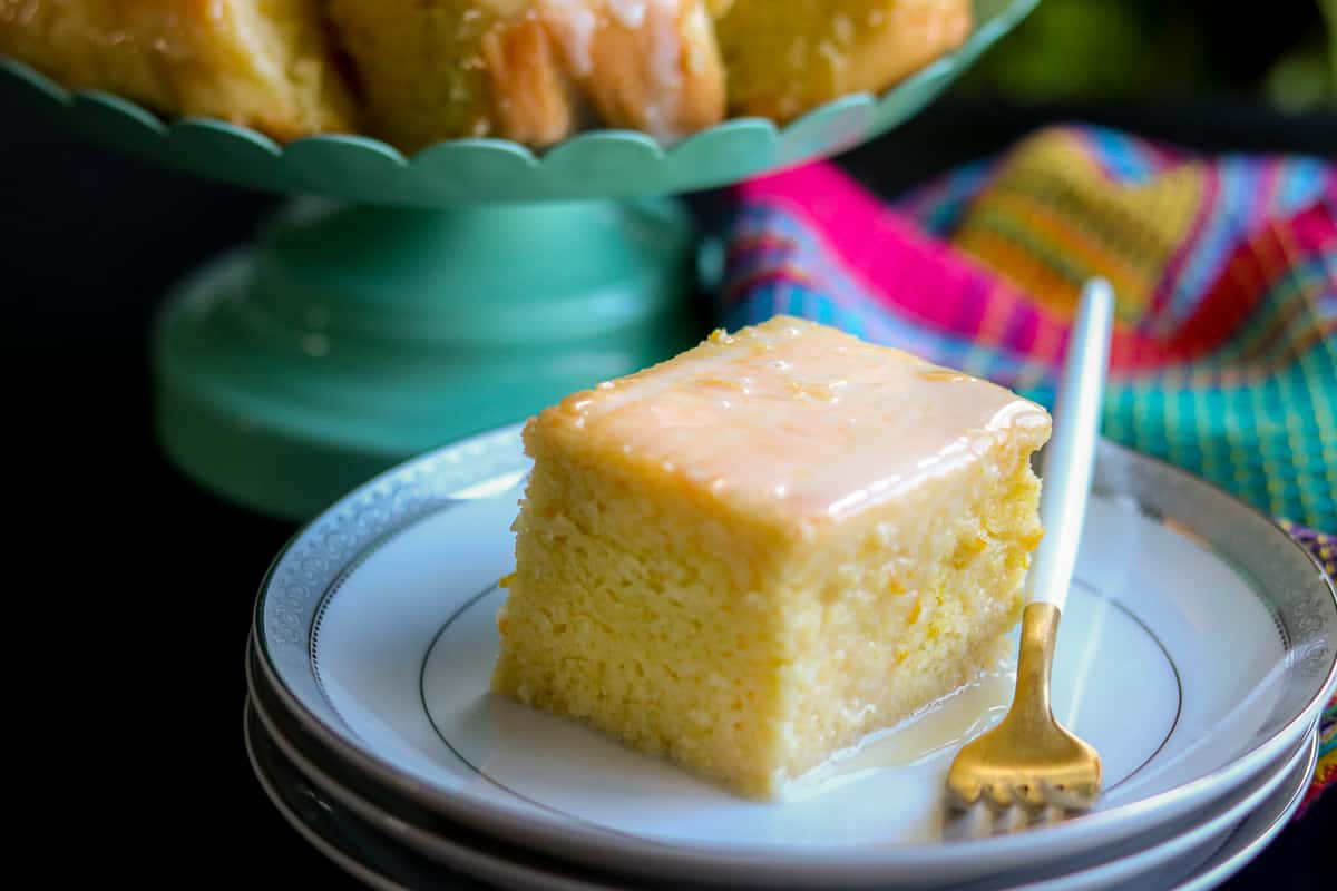 Zesty Orange cake square on white plate with fork