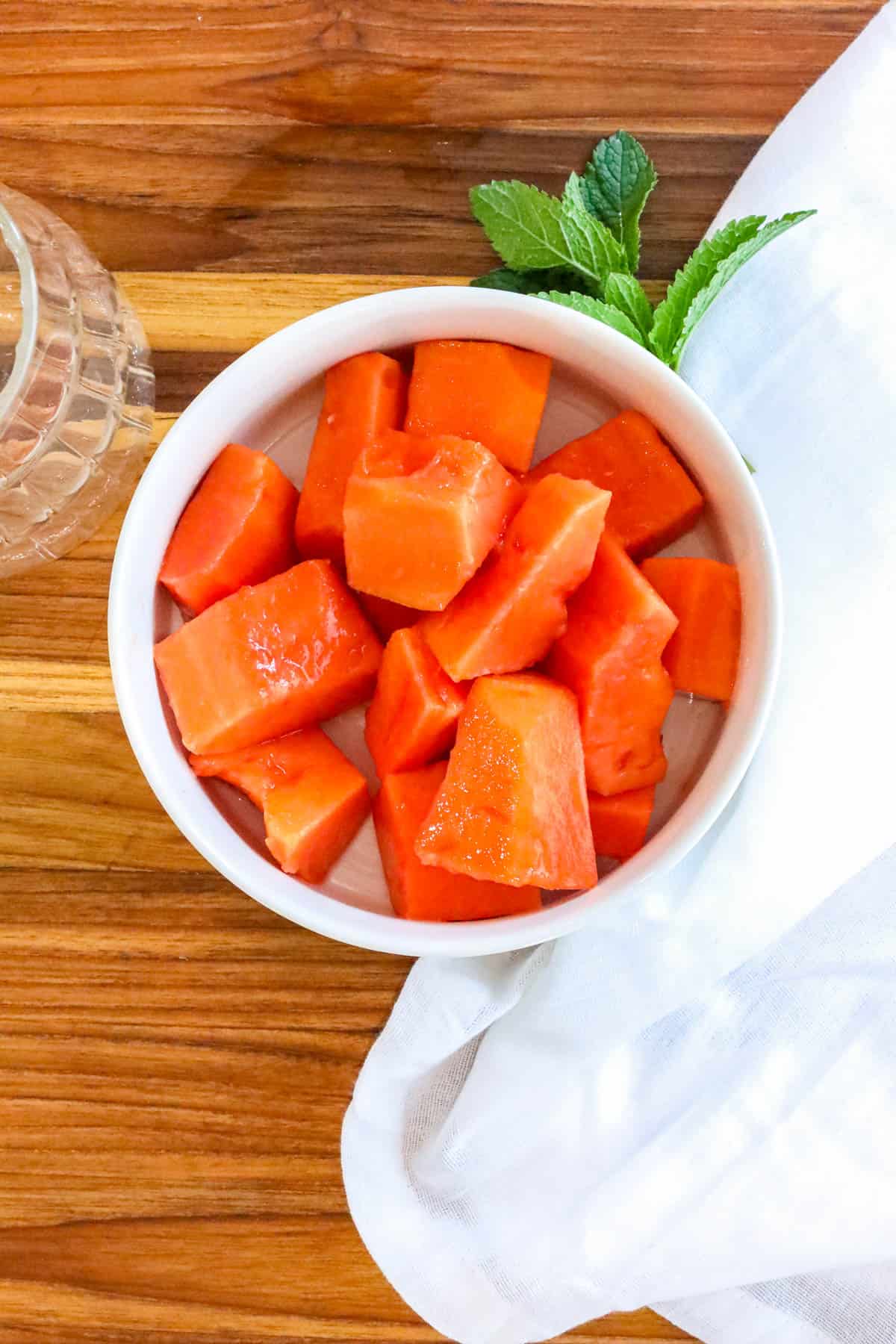 chunks of papaya in white bowl