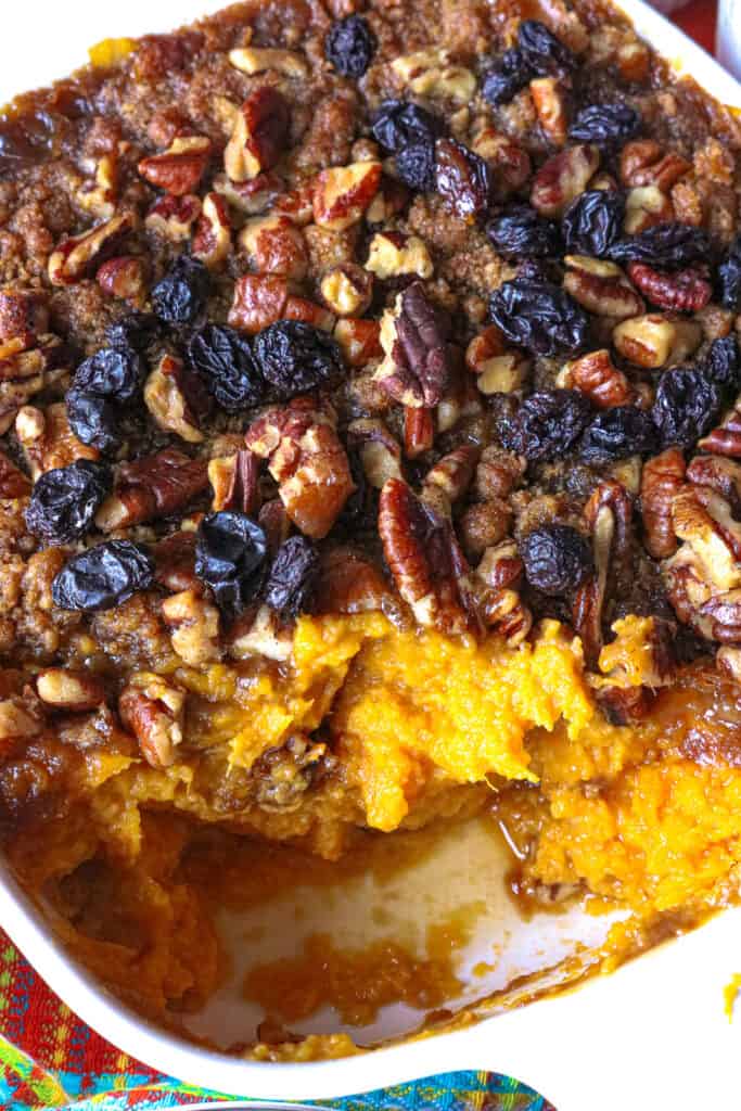 sweet potato casserole in white baking dish topped with raisins
