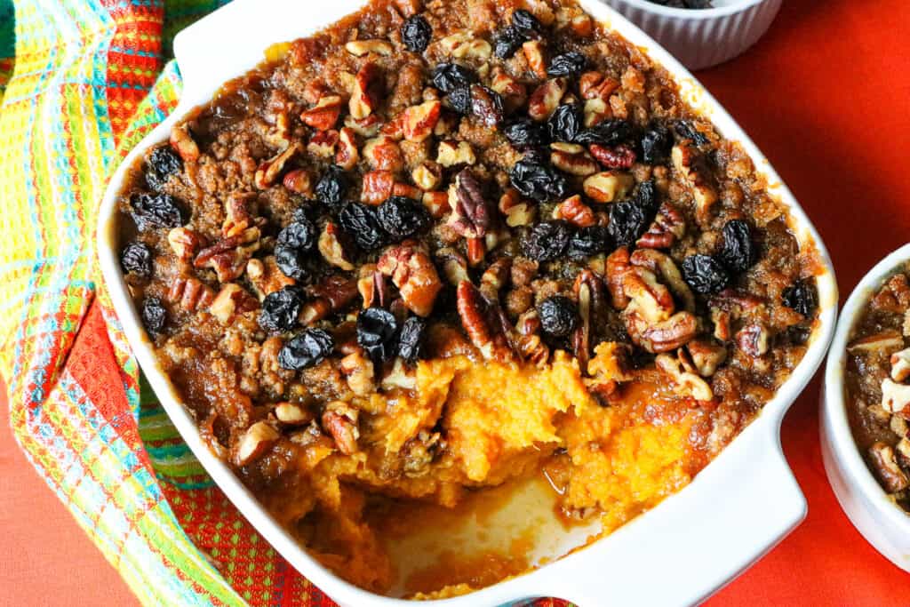 air fryer sweet potato casserole in white baking dish topped with raisins