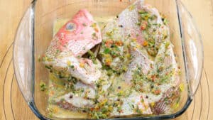 Fried Red Snapper topped with seasoning in clear dish