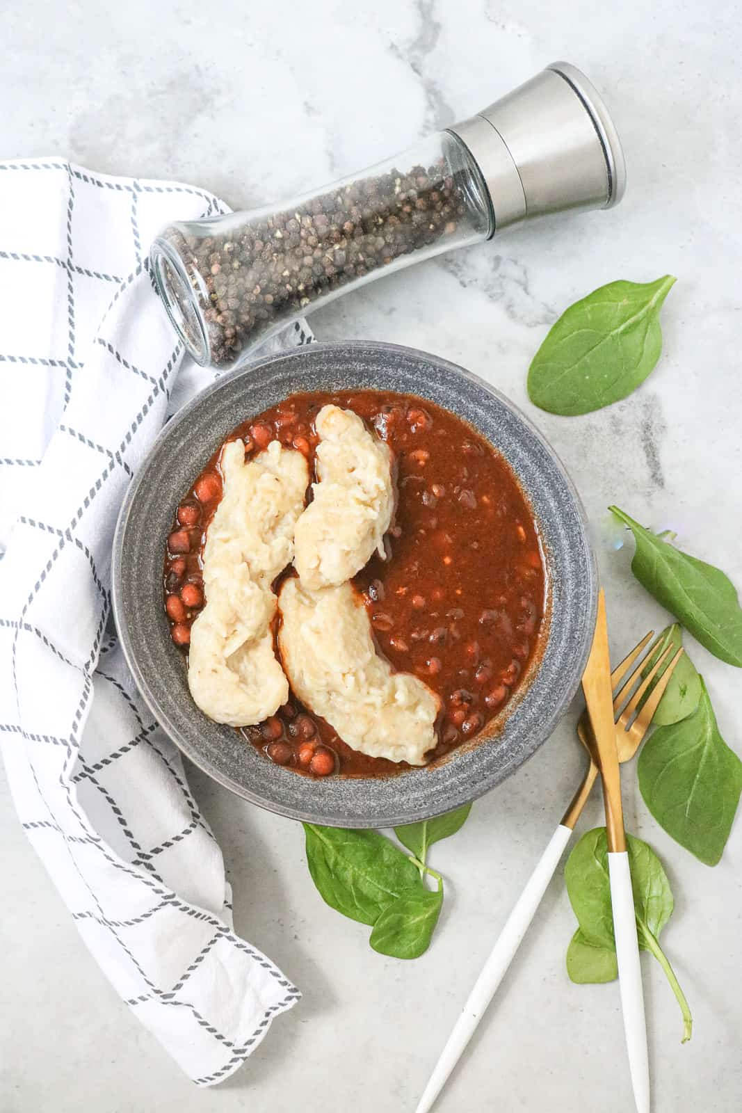 Haitian Boiled Dumplings In pigeon stew in gray bowl