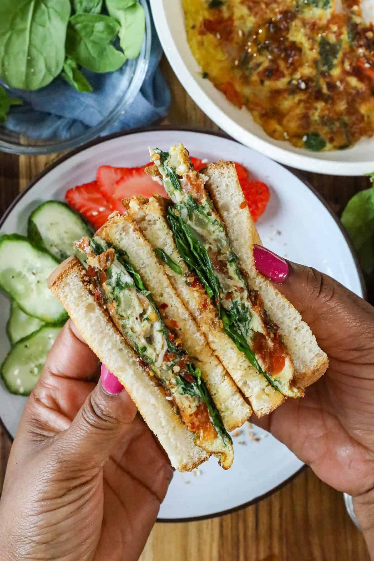 Hand holding egg sandwich