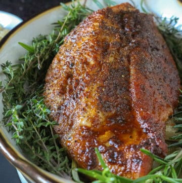 baked turkey breast in white dish with fresh herbs