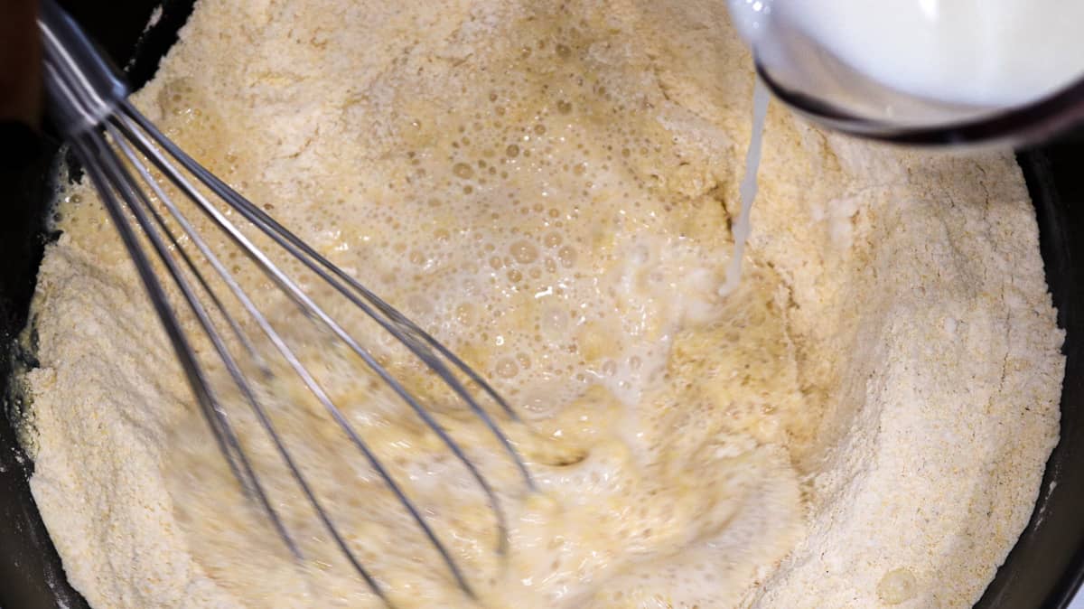 Milk being poured into the dry ingredients