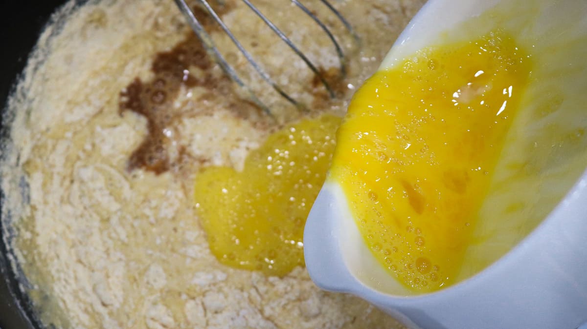 eggs being poured into dry ingredients