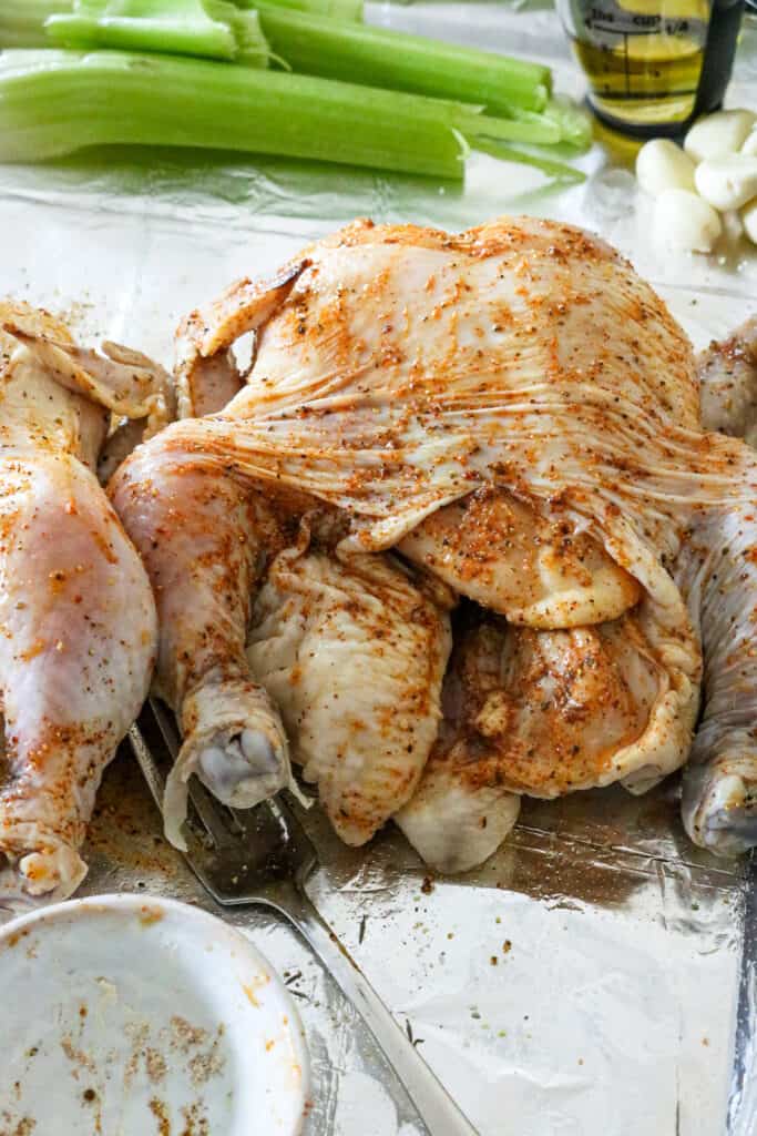 uncooked seasoned Cornish Hens with fork and celery