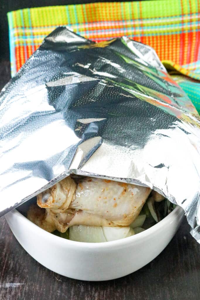 bird in baking dish covered with aluminum foil.