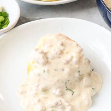 gravy over biscuits on a white plate