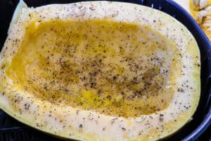 Half spaghetti squash season with salt and pepper and herbs