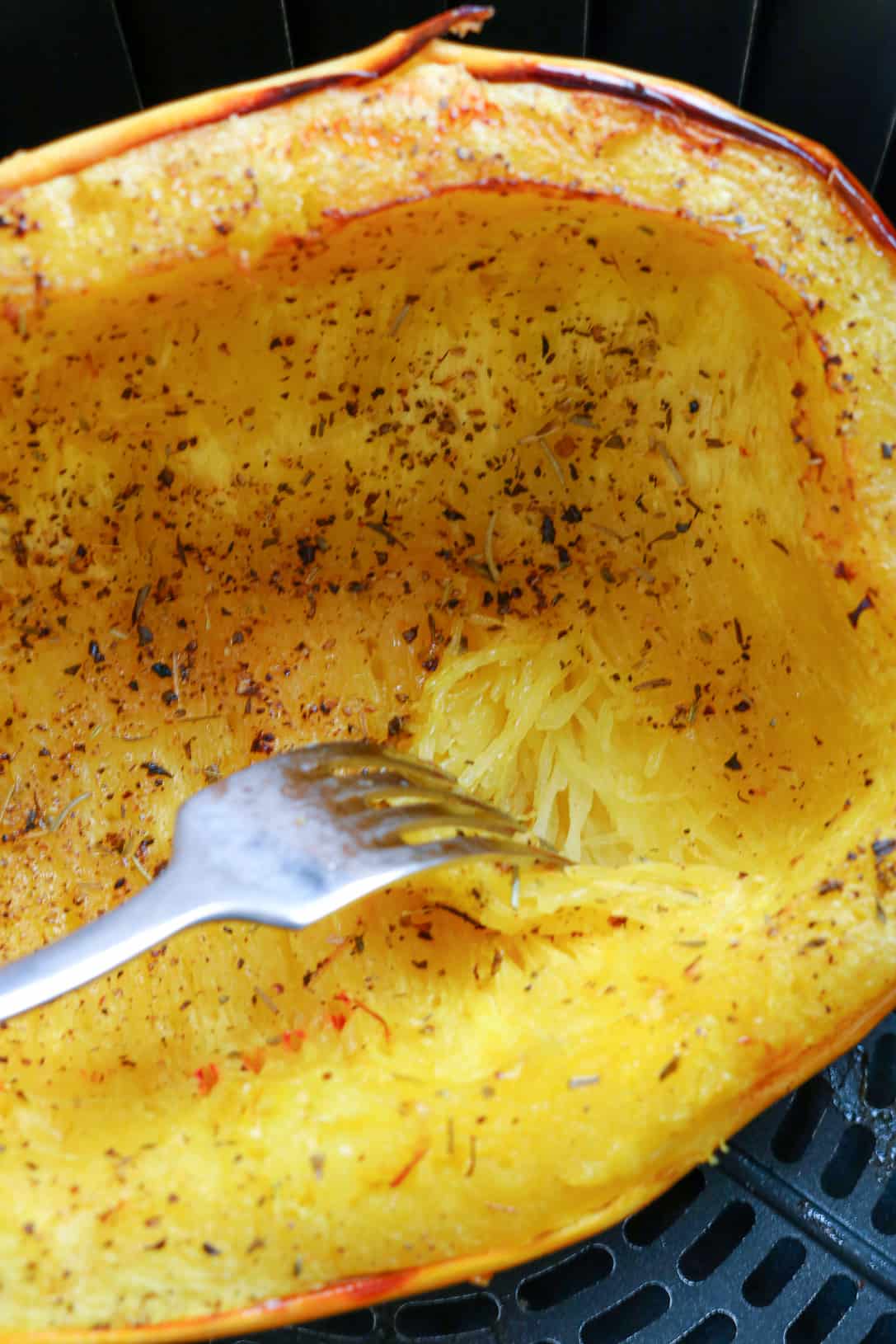 spaghetti squash in air fryer basket with fork