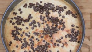 Air fryer cheese cake in baking pan topped with chocolate chips