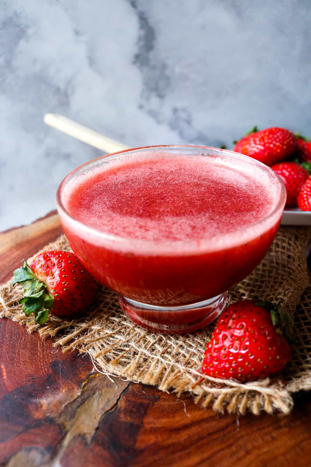 strawberry in clear container on wooden board