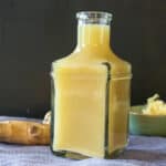 quick and easy ginger juice without a juicer. ginger tea in clear bottle with ginger in the background