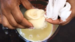 twisting juice out of cheesecloth in clear cup