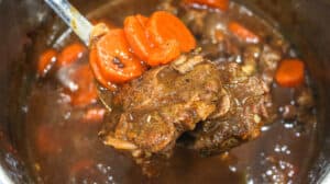 Cooked meat and vegetables on spoon lifted