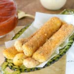 mozzarella sticks stacked up on green plate