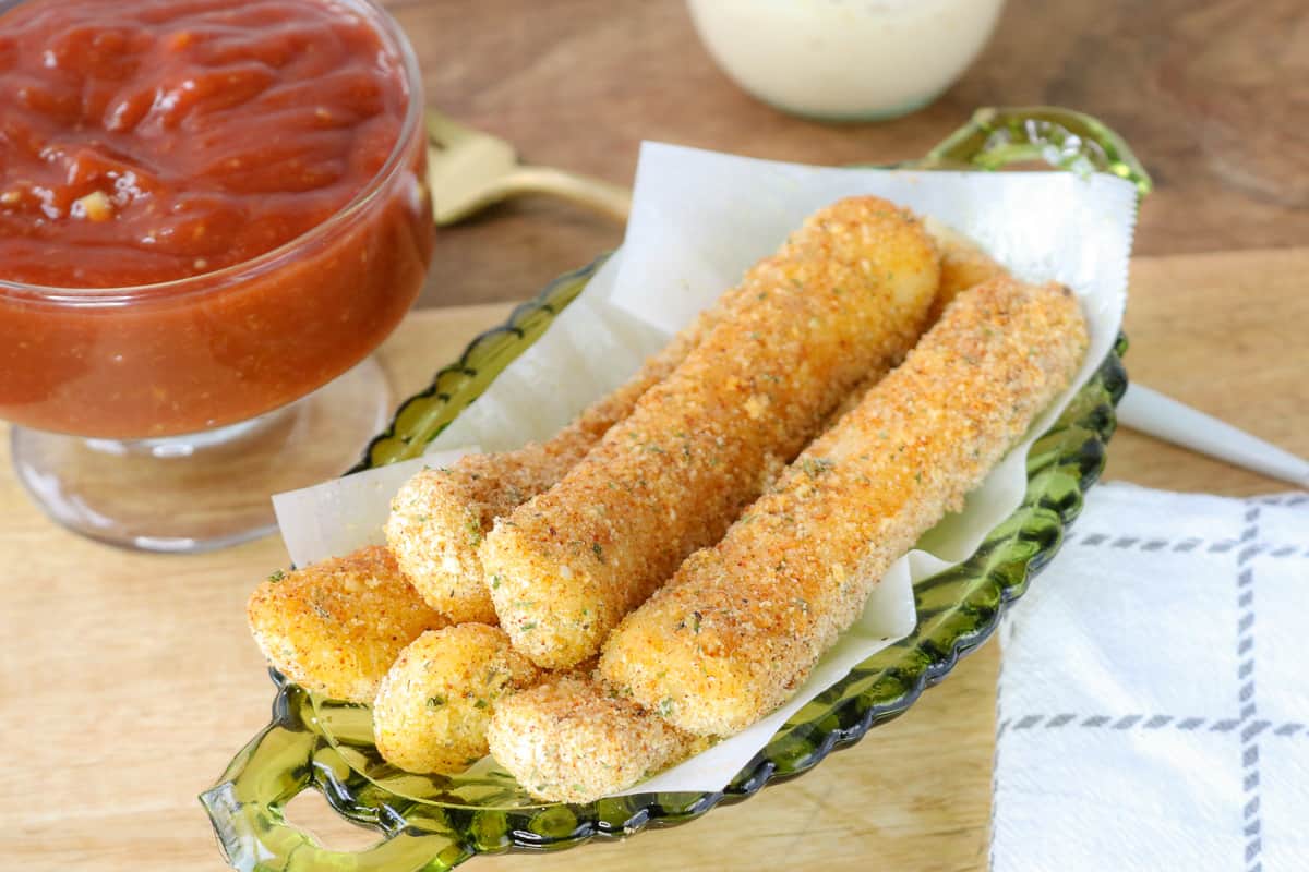 mozzarella sticks stacked up on green plate