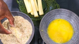 breadcrumbs, cheese stick and eggs in gray bowl