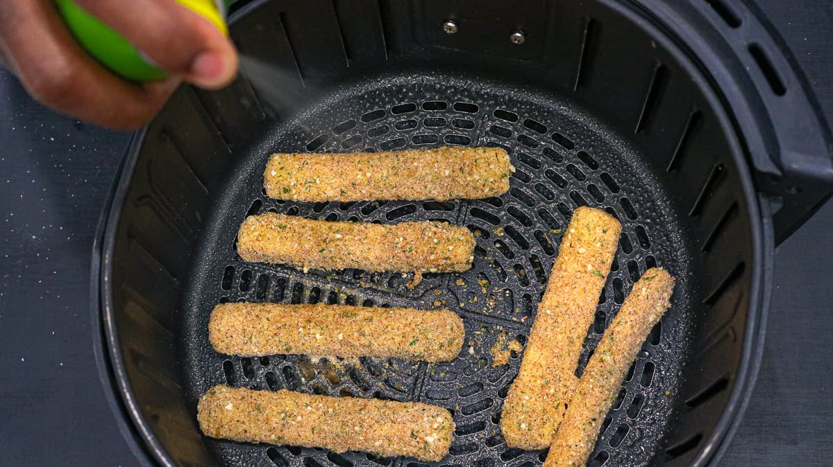 spraying sticks with olive oil spray