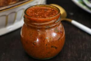 pepper sauce on brown board in clear jar
