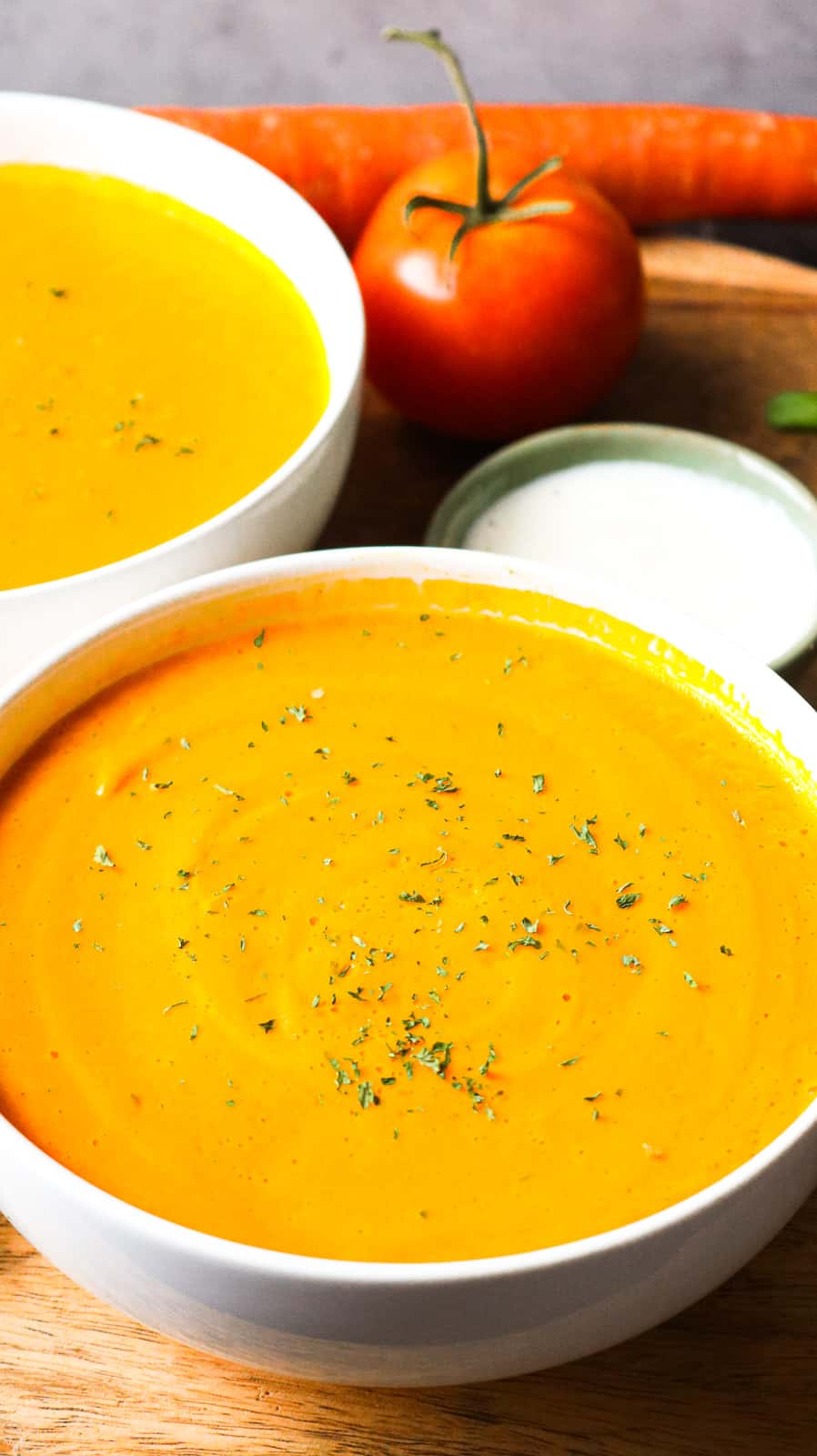 soup in white bowls topped with herbs