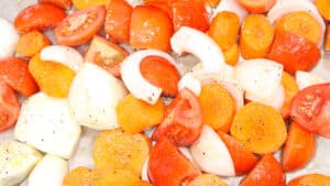 carrots, tomatoes, onions, topped with salt and pepper and olive in baking tray