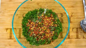 black pepper being added to herbs