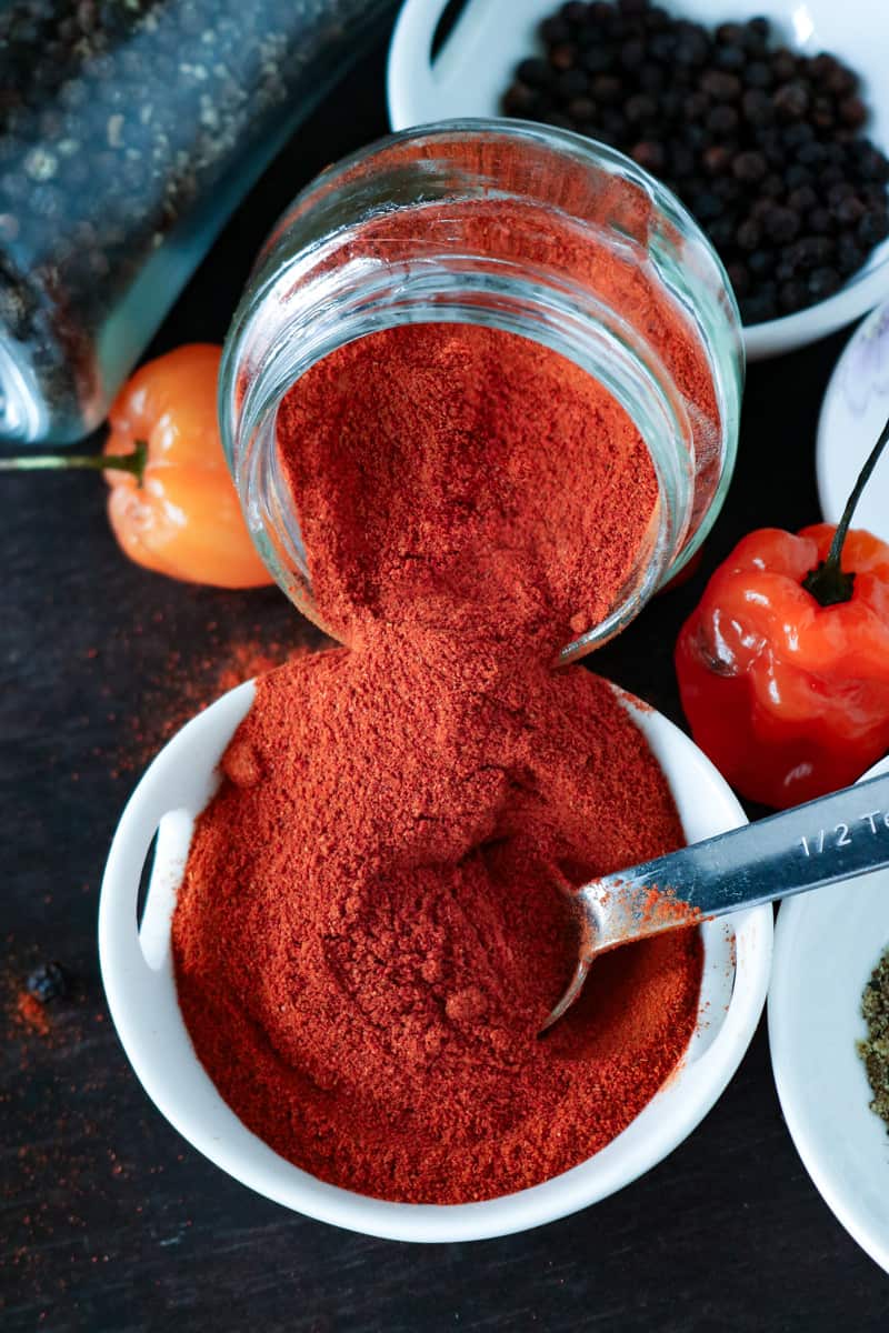 Cayenne pepper pouring in white bowl