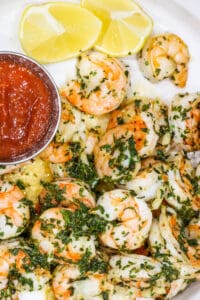 shrimp in white dish with sauce and herbs