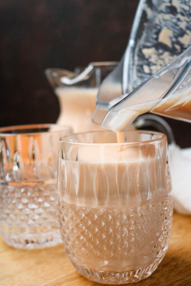 pouring smoothie in drinking glass