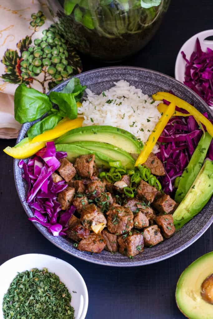 steak bites, rice, veggies on gray plate